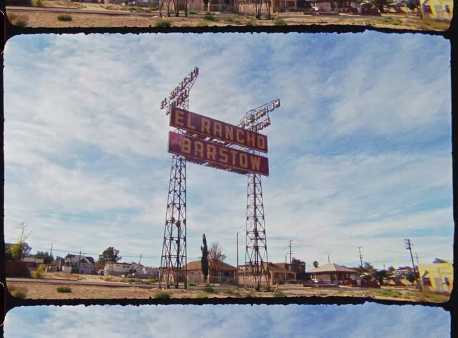 A large sign is in front of the small town