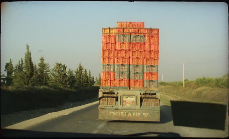 Truck traveling along the highway carrying several orange boxes