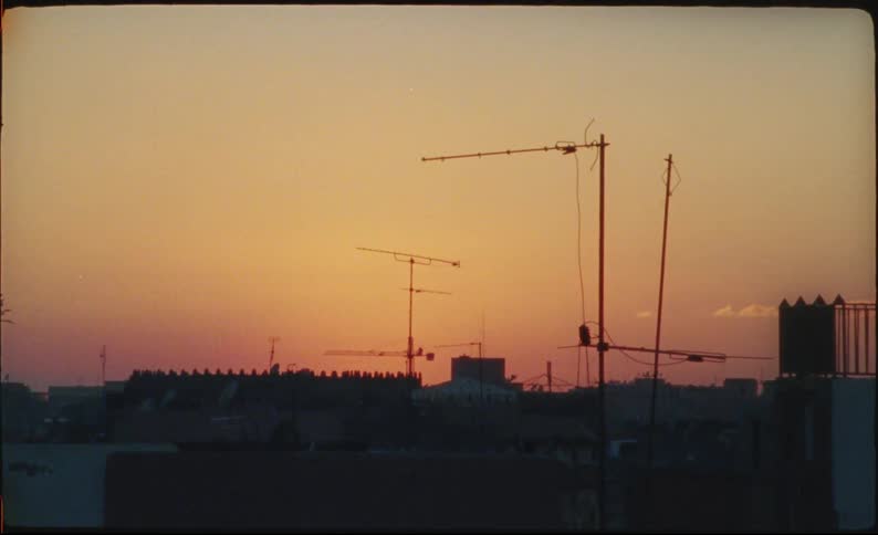 Urban skyline at sunset with antennas and building silhouettes
