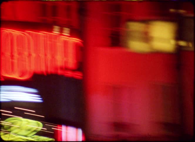 A view of some buildings at night with neon lights