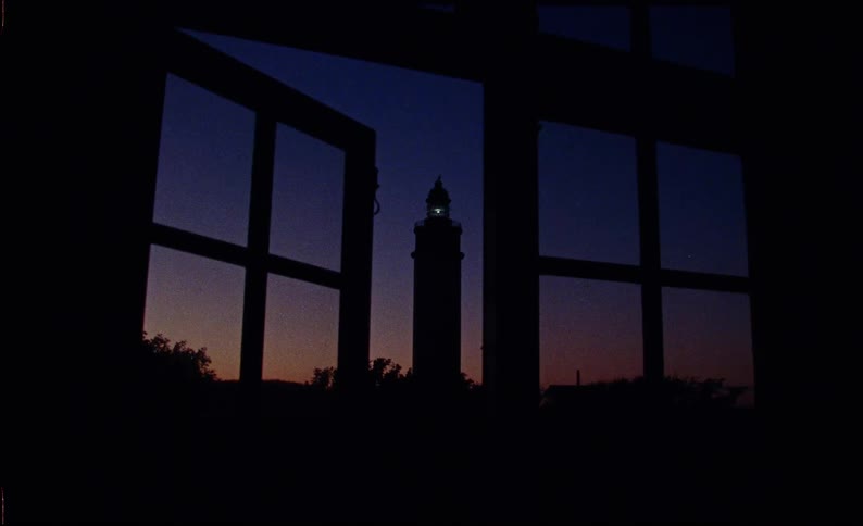Silhouette of a tower seen through a window at night