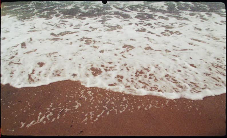 Waves roll in over the sand on the beach