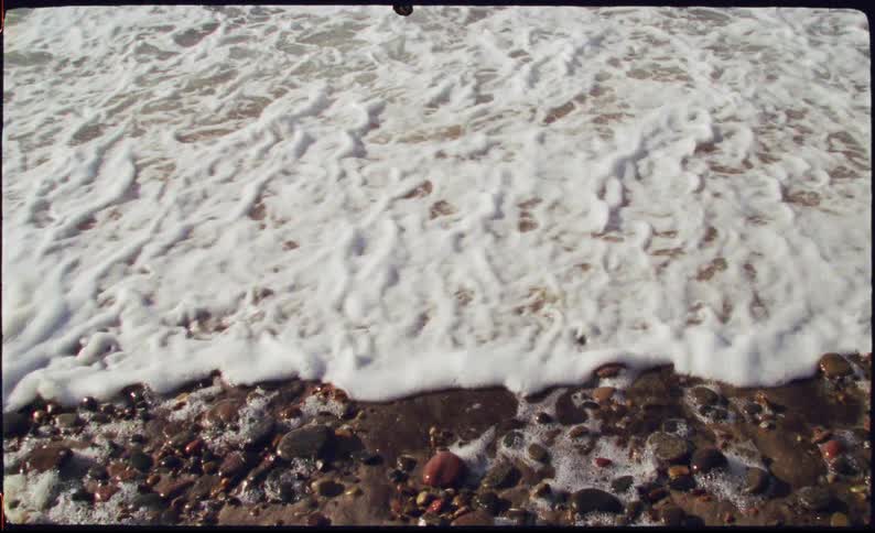 Sea tide going over pebbles and sand at a beach outdoors during day time