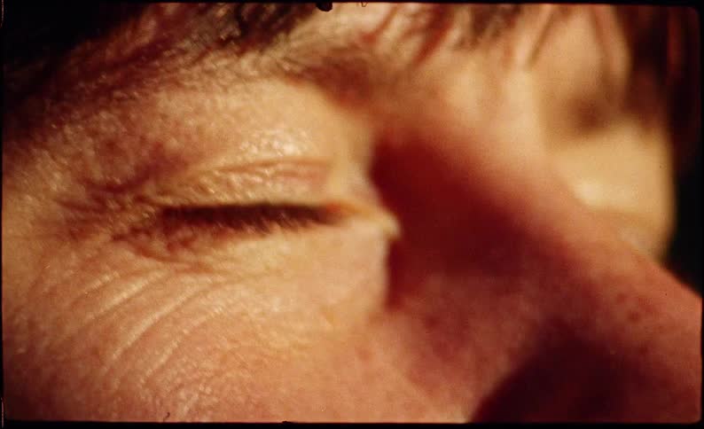 Close up of a person opening and closing their eyes while looking at the sunset