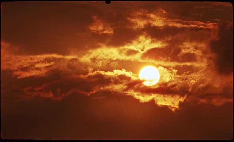 Sun on the sky covered by moving clouds outdoors during dusk or dawn