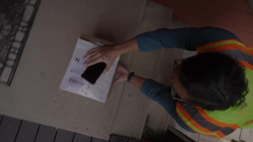 Man leaving a box on a staircase in an outdoor area