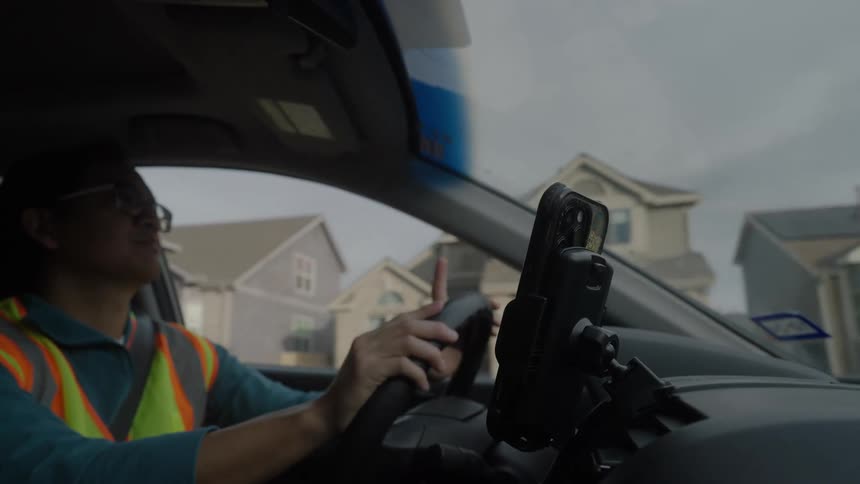 The man is tapping his steering wheel as he drives