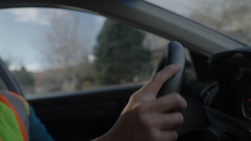 Person driving and hitting the steering wheel with their hands