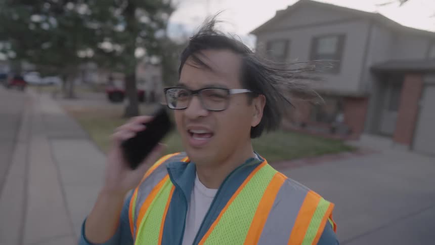 The man answers his cell phone while walking