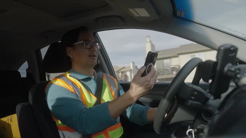 Man talks on his phone as he drives an automobile