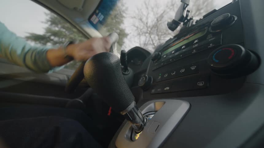 Man getting into a car and starting to drive
