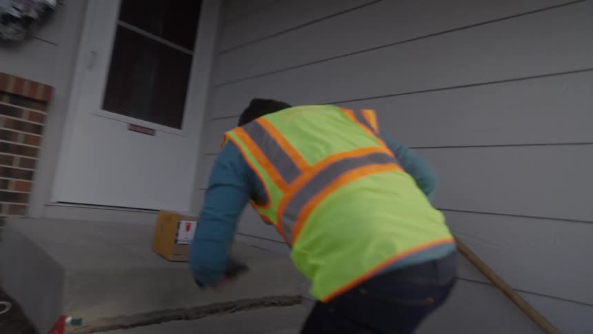 The man delivers a package and takes a photo