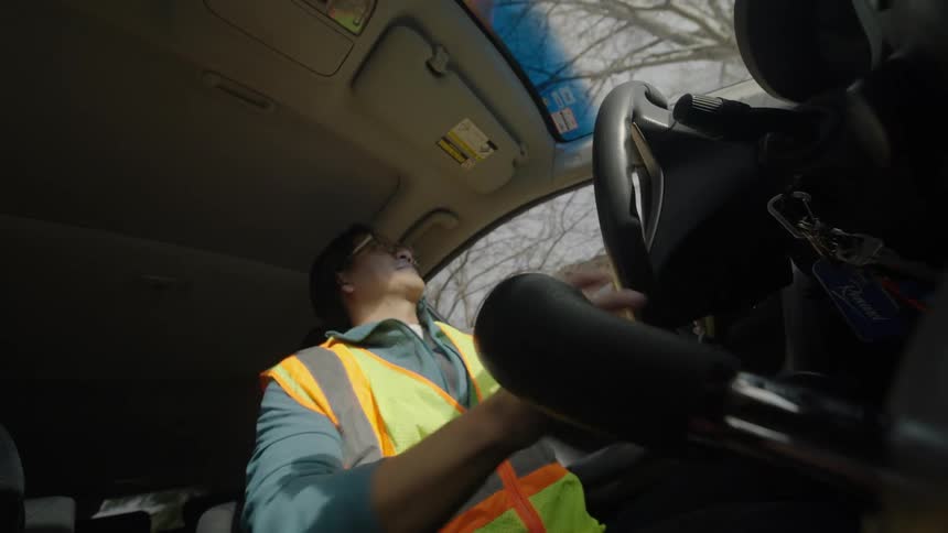 Young man gets inside his open car door and drives away