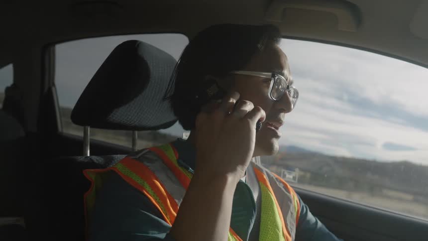 The man is talking on his cell phone while driving