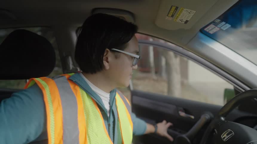 The delivery driver stops the car and grabs packages