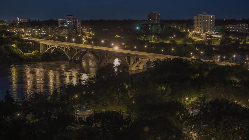 A bridge is bright lit and has cars traveling over it