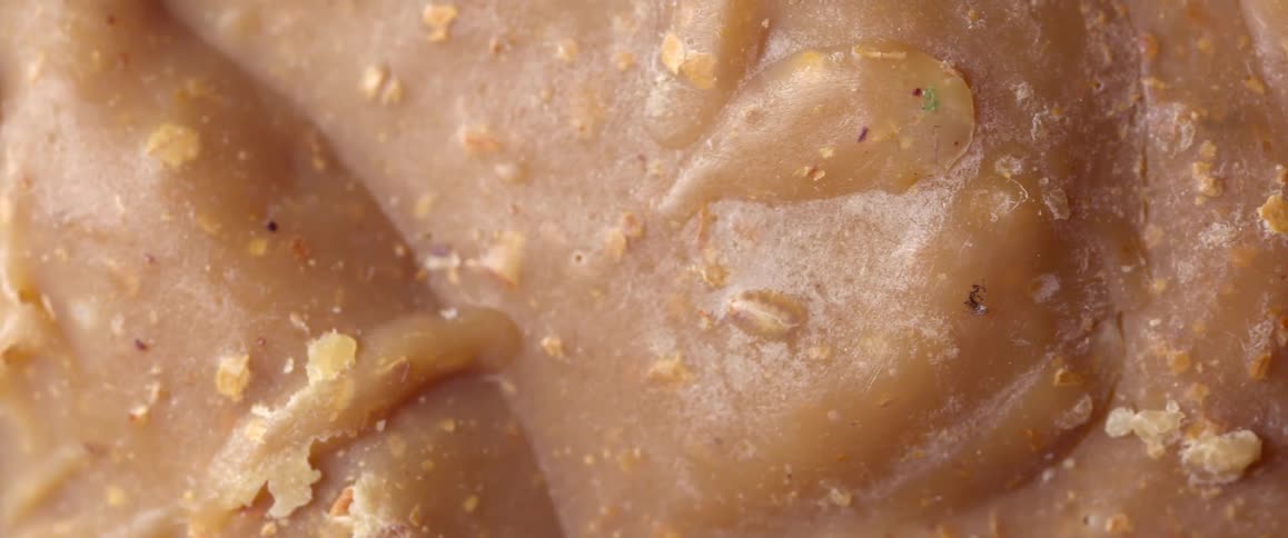 Flakes lie on the surface of a smooth light brown mixture