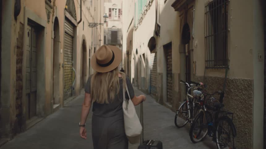 Woman walking with a suitcase in an urban hallway
