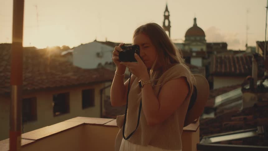 Woman in an urban area at the end of the afternoon taking photographs