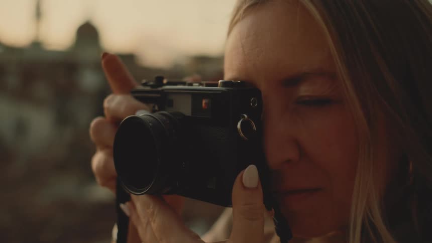 Young woman holds her camera and takes a picture
