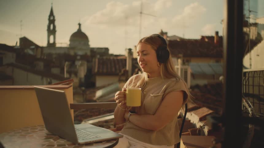A woman talking on a laptop while sitting outside