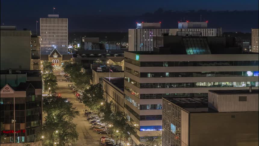 The city has lights at night as cars drive through