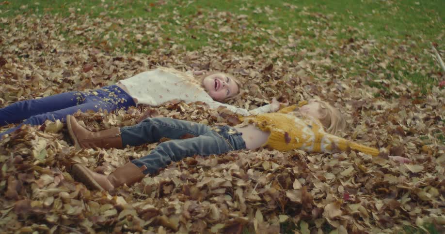 The girls land in the pile of leaves