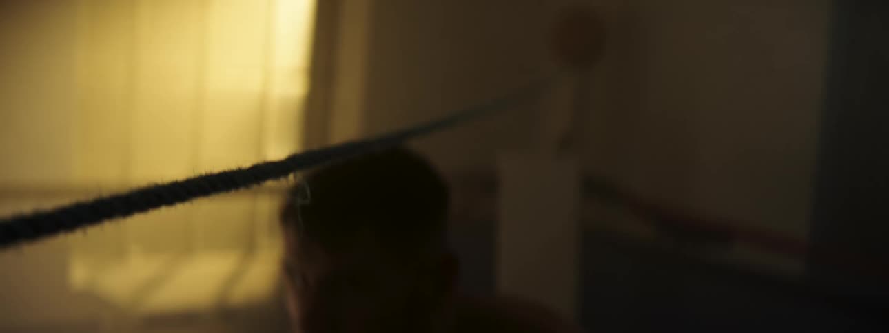 A person is ducking while dodging a rope in a dark room