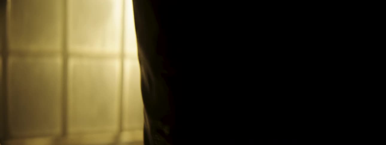 Boxer practices punches on a punching bag in a lowlight environment