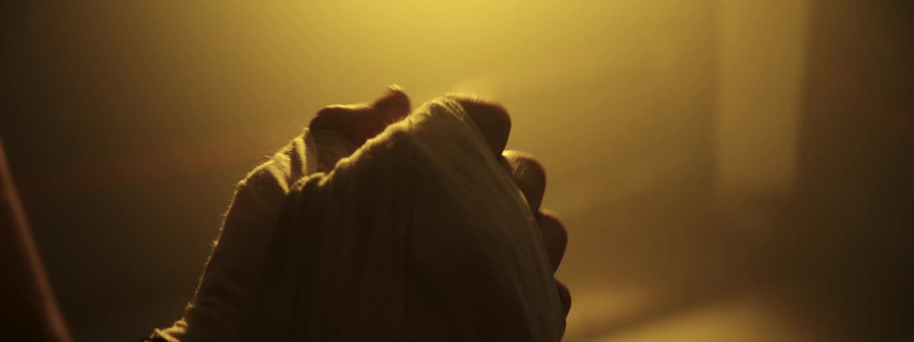 Wrapped fists under warm lighting in an indoor setting