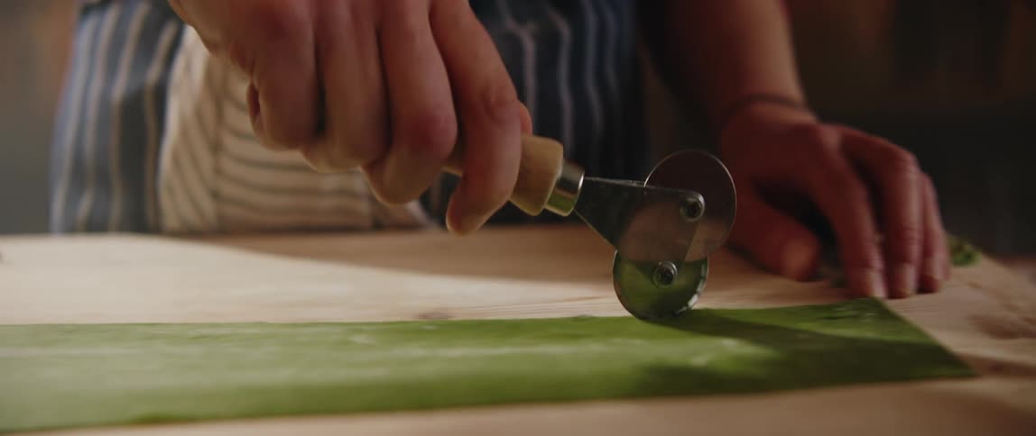 A person using a tool while cooking