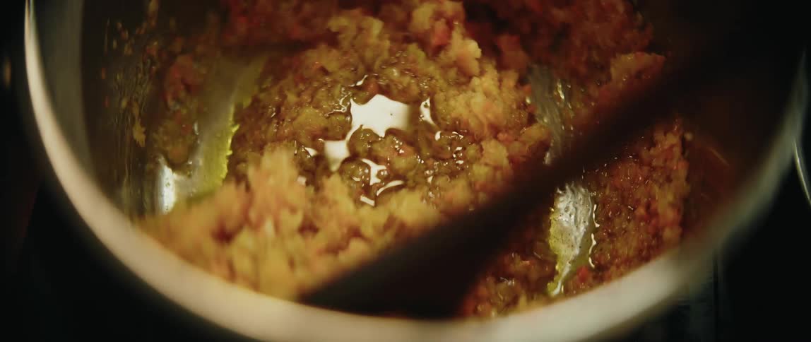 Sauted chopped ingredients being stirred in a pot with hot oil