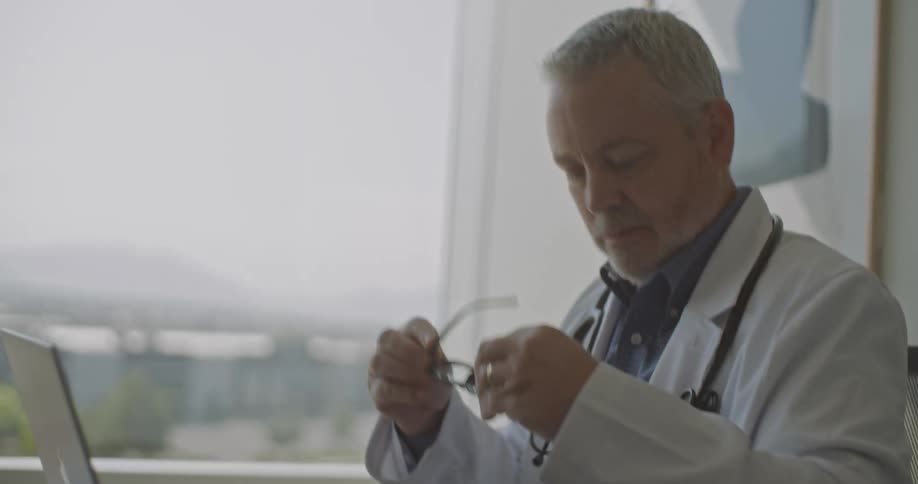 A man writing in a paperwork an then taking off his glasses and keeping them in his pocket