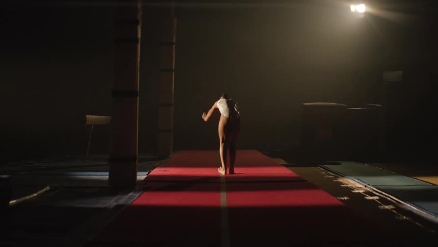 A gymnast performing back handsprings down a red mat