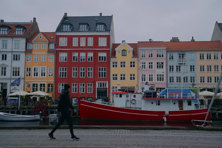 Pedestrians and cyclists walk beside the river in a residential area