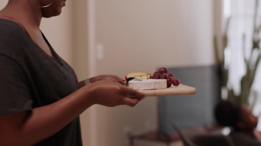A woman pulls grapes out of a basket