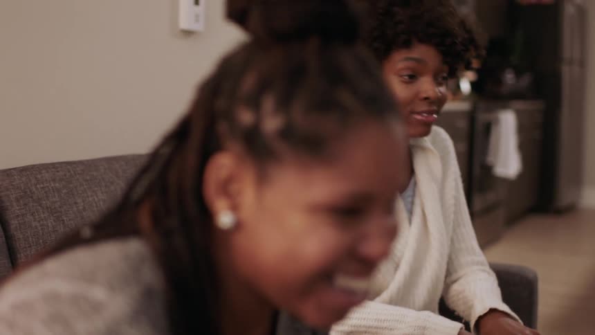 Women sitting on a couch and talking with some friends