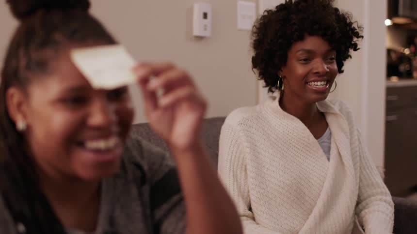 The women laugh and play a game together