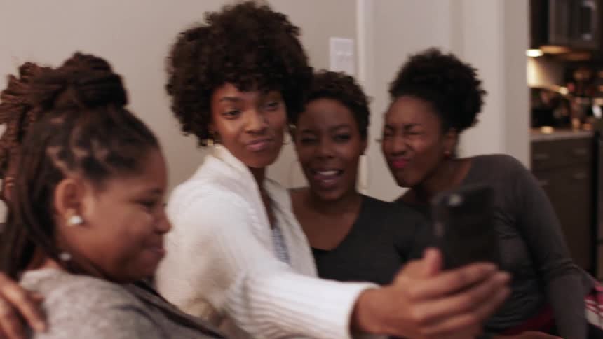Women smile and take a group selfie