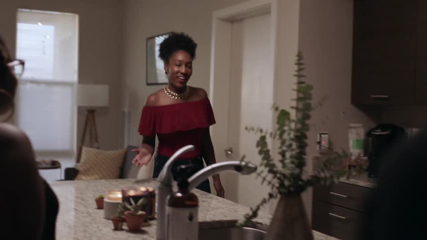 Women talk and stand by a sink