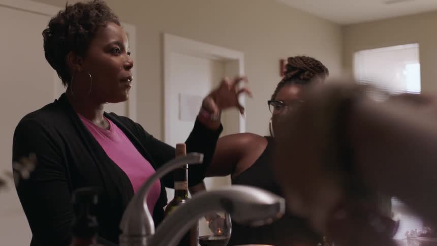 A woman talks with her friends while they listen