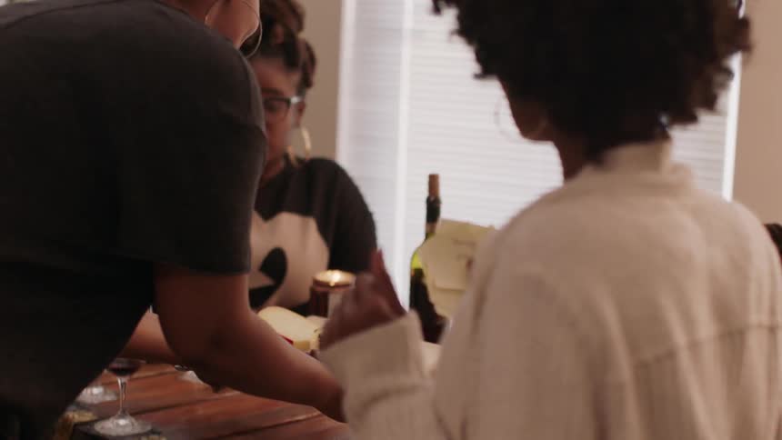 A woman serves some fruit and cheese to a table
