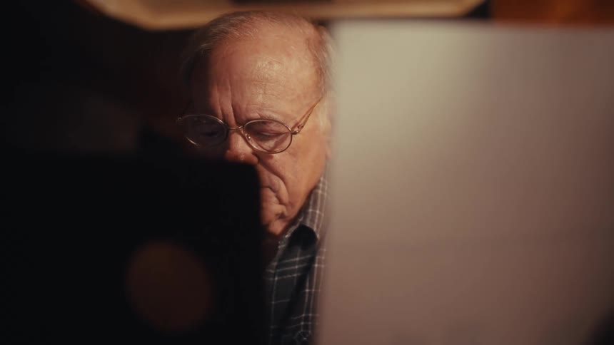 A man looking at a piece of paper in a room