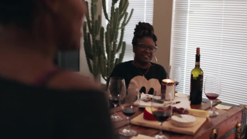 Women talk together with drinks and food