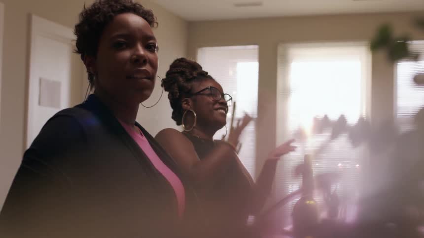 A group of people talk and clap hands in the kitchen