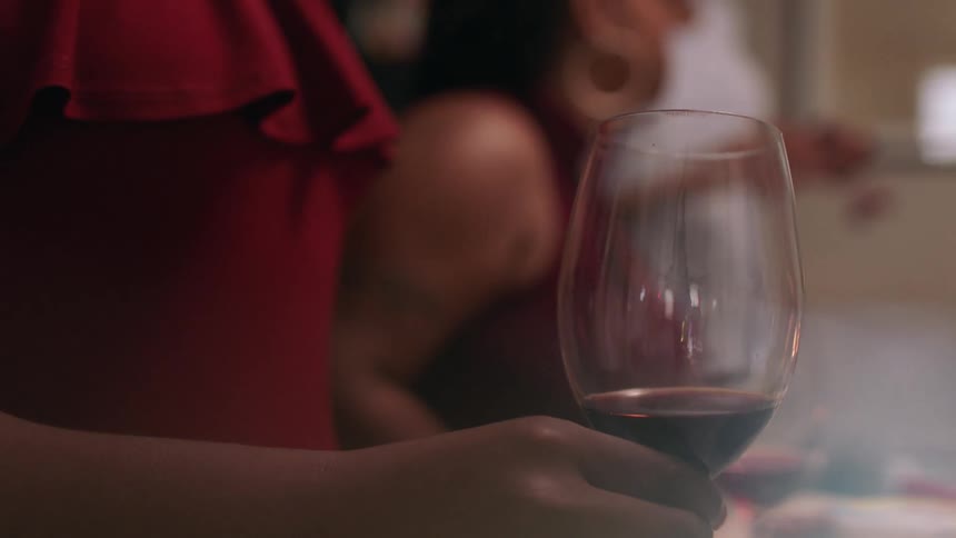 A woman rolls wine in a glass