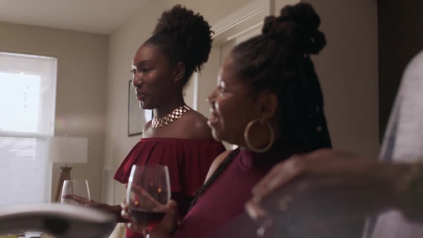 The women nod and laugh as they drink wine