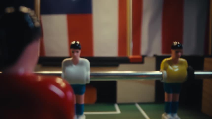 A foosball table inside a room illuminated by bright even light
