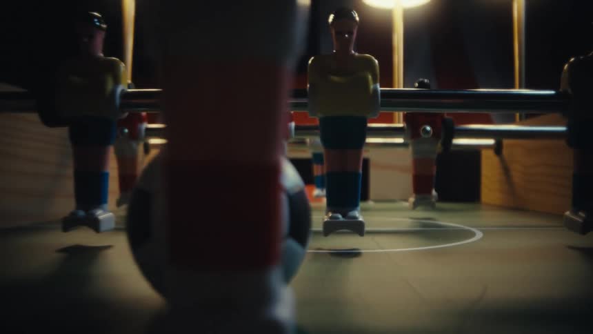 Foosball table with a small ball positioned in the center