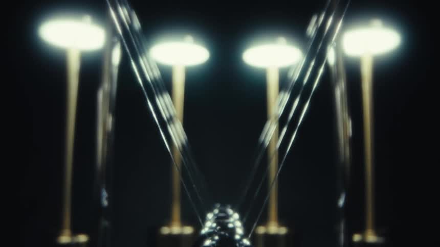 A newtons cradle swings in motion under dim lights against a dark background
